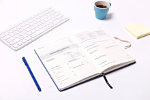 Load image into Gallery viewer, side angle view daily journal pages open on table. Clear view of Habit planning and tracking sections