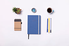 Load image into Gallery viewer, Overhead view of Reboot Habit Journal on white table with pens and a notebook